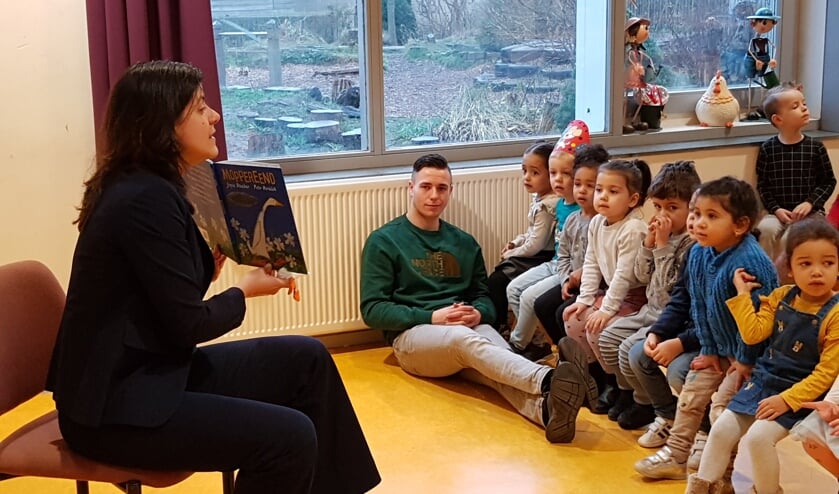 De wethouder leest voor, de kinderen luisteren.