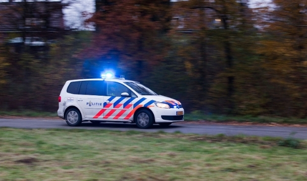 Politieauto met zwaailicht aan.