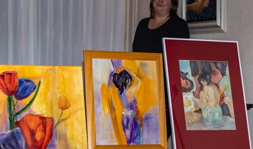 Karin Hoogland met een aantal te veilen schilderijen van haar moeder.