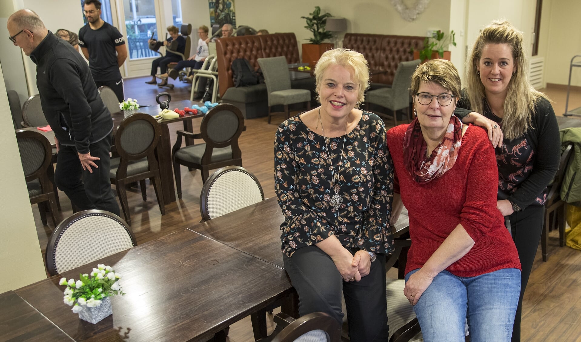 Karin Huisman, Jolanda Mol en Dionne Dekker (v.l.n.r.) in restaurant de Oude Dame in De Wilgenhof. Op de achtergrond is de fitnessochtend in volle gang.