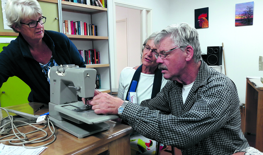 Samen met vrijwillgers kapotte gebruiksvoorwerpen repareren.