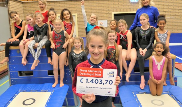 Een blije groep kinderen met de cheque en de nieuwe matten.