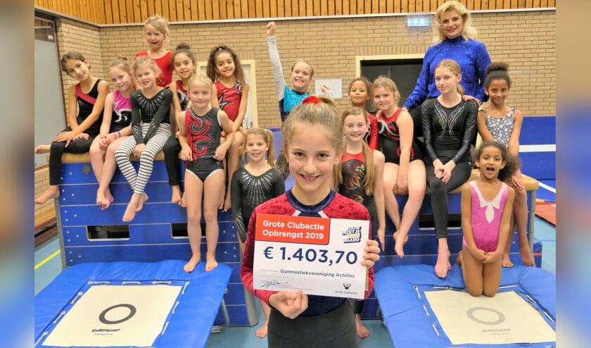 Een blije groep kinderen met de cheque en de nieuwe matten.