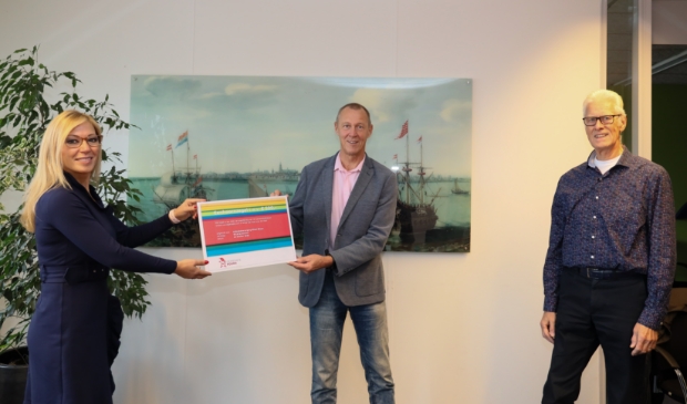 <p>Wethouder Kholoud al Mobayed reikt een Eenhoornzegel uit aan voorzitter Henk Snoeijer en penningmeester Jan van den Bos. </p>