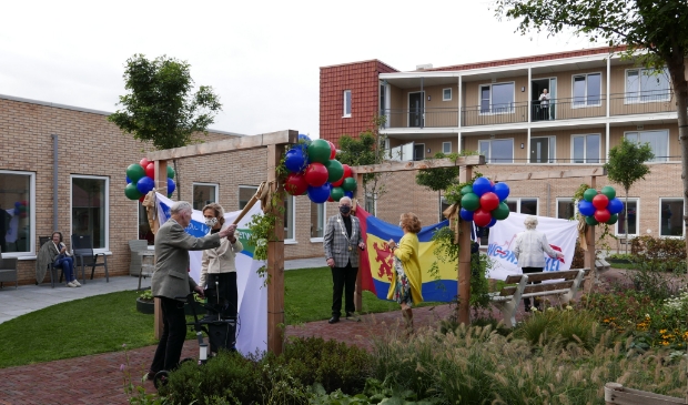 <p>Bestuurderskwaliteitsverpleegkundige en twee bewoners na de opening.</p>