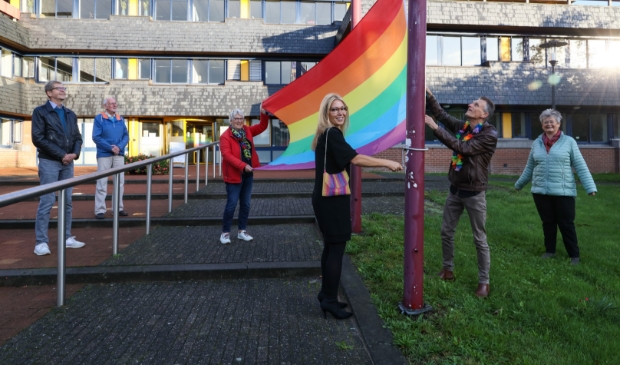 <p><em>In het midden wethouder Kholoud Al Mobayed die de regenboogvlag voor het stadhuis hijst. Links van haar houdt Rita Zwaan de vlag vast. </em></p>