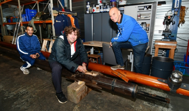 <p>Rick den Hollander, rechts, in de werkplaats met twee deelnemers. </p>