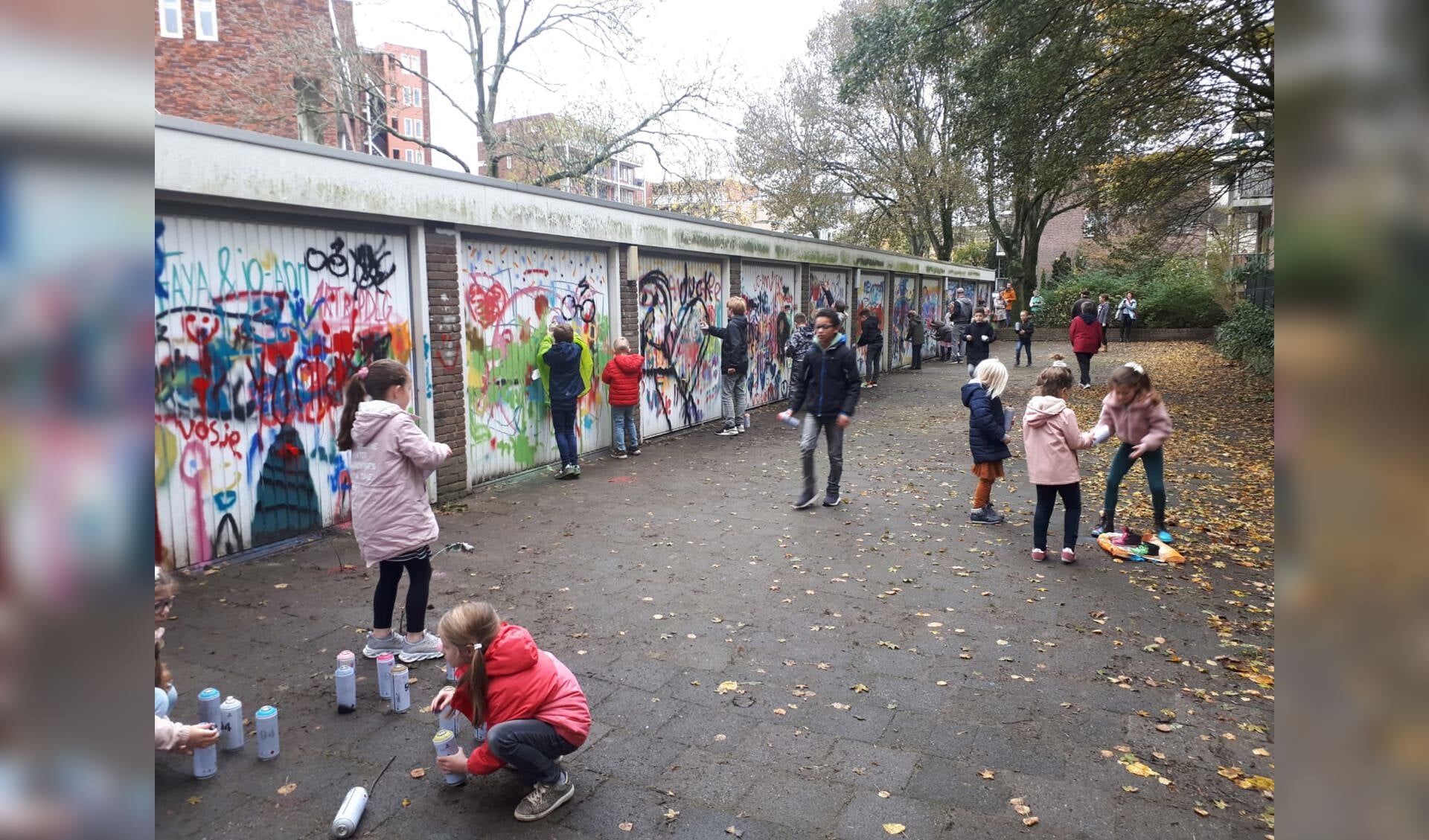 Kinderen uit Delftwijk zijn druk bezig met het versieren van de garagedeuren. 