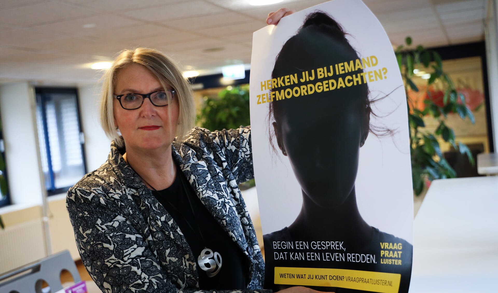 Wethouder Marjon van der Ven met de campagneposter om inwoners bewuster te maken van hun helpende rol bij zelfmoordpreventie.