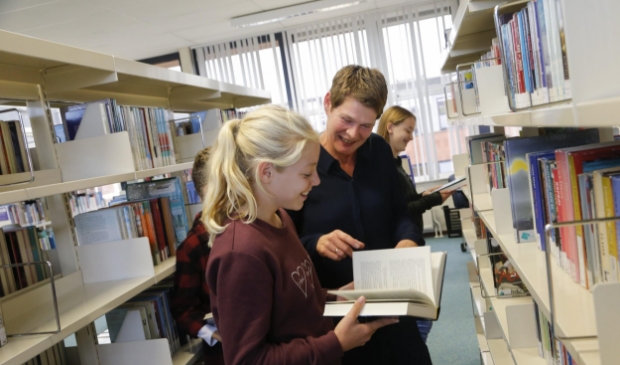 <p>Linda Visser adviseert een leerling in de mediatheek op het Martinuscollege.</p>