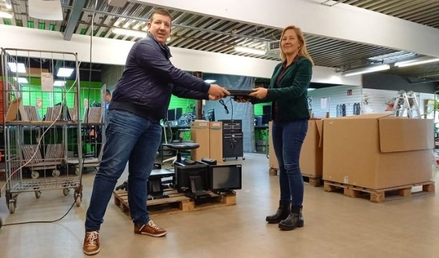 <p>Björn Ham neemt laptop in ontvangst van Kim Bakkum.</p>
