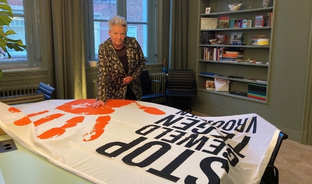 <p>Wethouder Elly Konijn bij de vlag 'Orange the World'. </p>