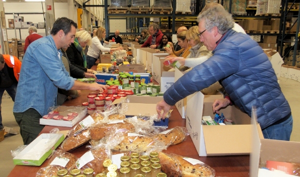<p>Leden van de rotaryclubs helpen bij het inpakken van de pakketten.</p>