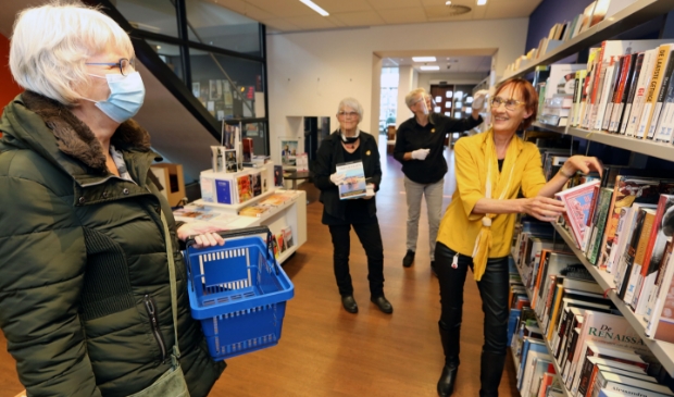 <p>Vestigingscoördinator Karin Tacx (met gele blouse) is blij dat ze weer bezoekers mag ontvangen in de bibliotheek Schagen.</p>