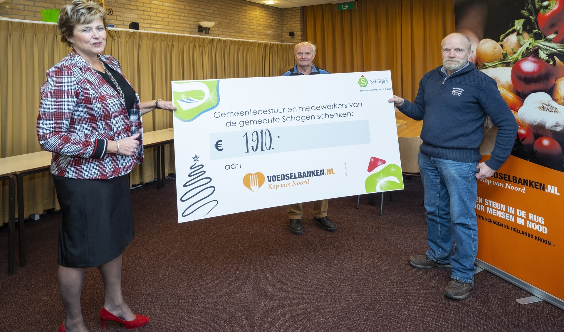 Burgemeester van Kampen reikt de cheque uit aan de penningmeester van de Voedselbank.