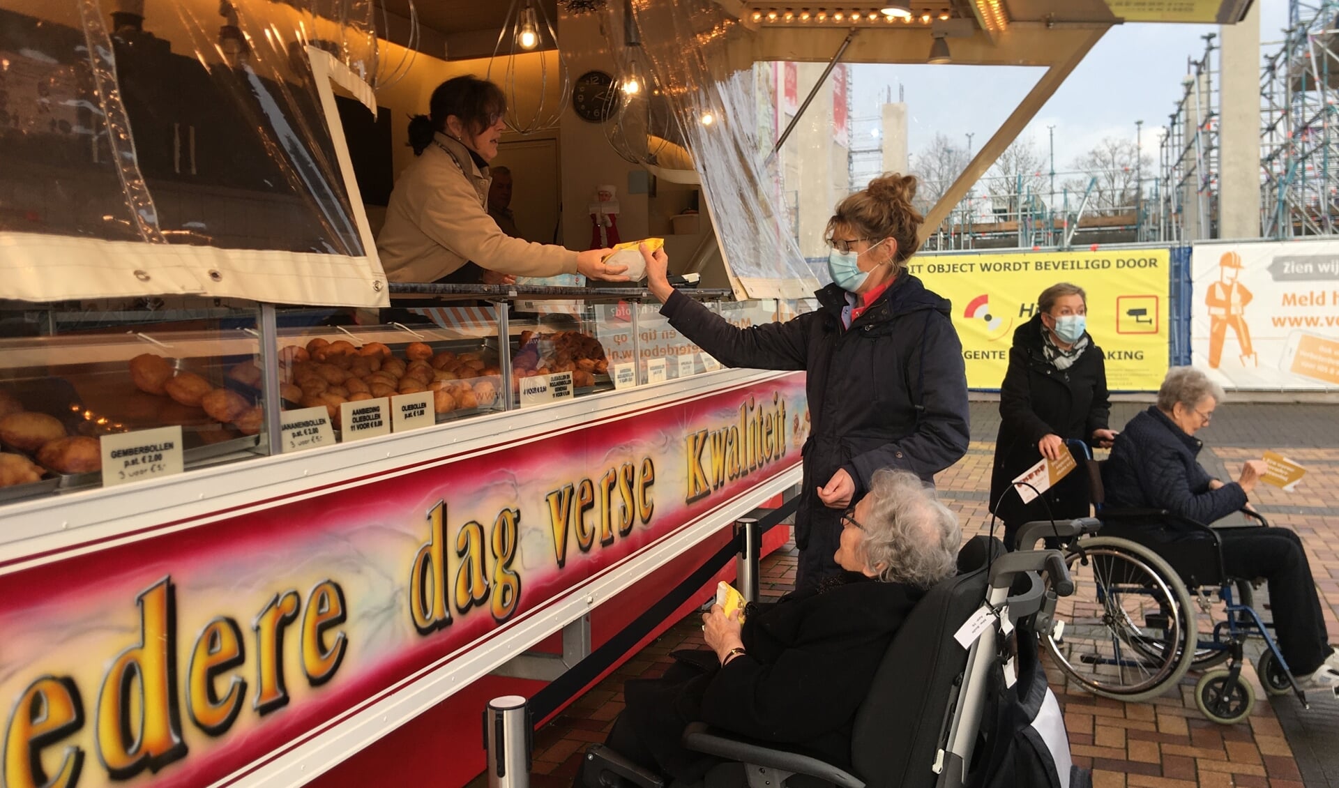 Senioren genieten van een smakelijke oliebol.