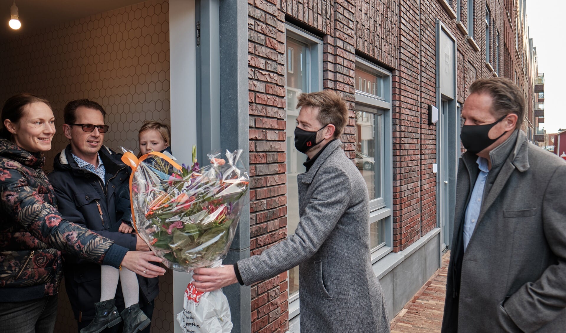 Bewoners van laatste opgeleverde aardgasvrije woning ontvangen een bloemetje uit handen van wethouder Christian Braak.