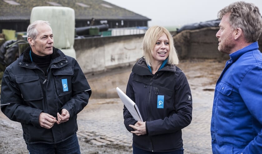 Toezichthouders Mariëlle Schagen en Bart Sprenkeling in gesprek met veehouder Jan Out (r).