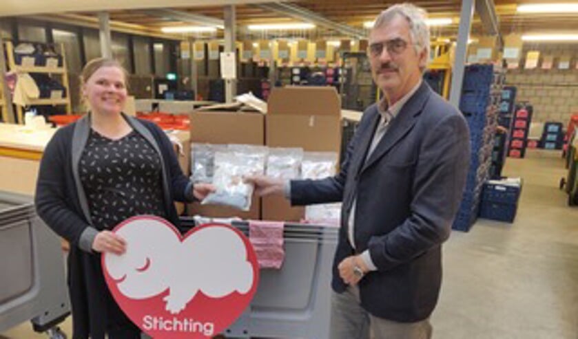 Marjolijn Hermus van Stichting Babyspullen neemt de rompertjes van Kiwanis dankbaar in ontvangst.