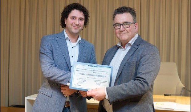 Wethouder Mario Hegger neemt namens wethouder Paul van Meekeren (portefeuillehouder Duurzaamheid) de Oorkonde Materialenpaspoort in ontvangst.
