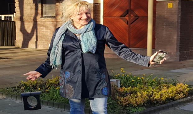 Mirjam Sloots voor De Ontmoeting met de kinderlantaarn van de kerk als teken van licht van God en haar gsm vanwege de mogelijkheid van digitale ontmoetingen.