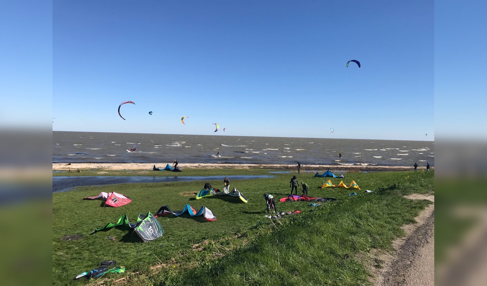 Vele kitesurfers op de gouwzee maakten dankbaar gebruik van de krachtige wind en dit resulteerde in een aanzicht met diverse gekleurde 'kites' aan een tamelijk stralend blauwe hemel. 