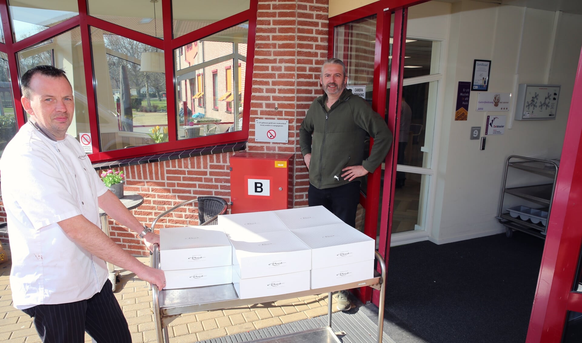Elco Oudshoorn van bakker Roos en ds. Engele Wijnsma trakteren de ouderen op een gebakje.