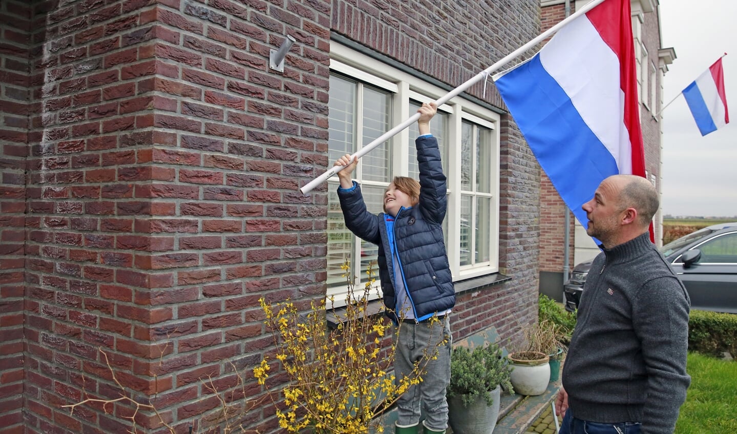 Stefan en zijn zoontje hingen vrijdagochtend de vlag uit als steunbetuiging.