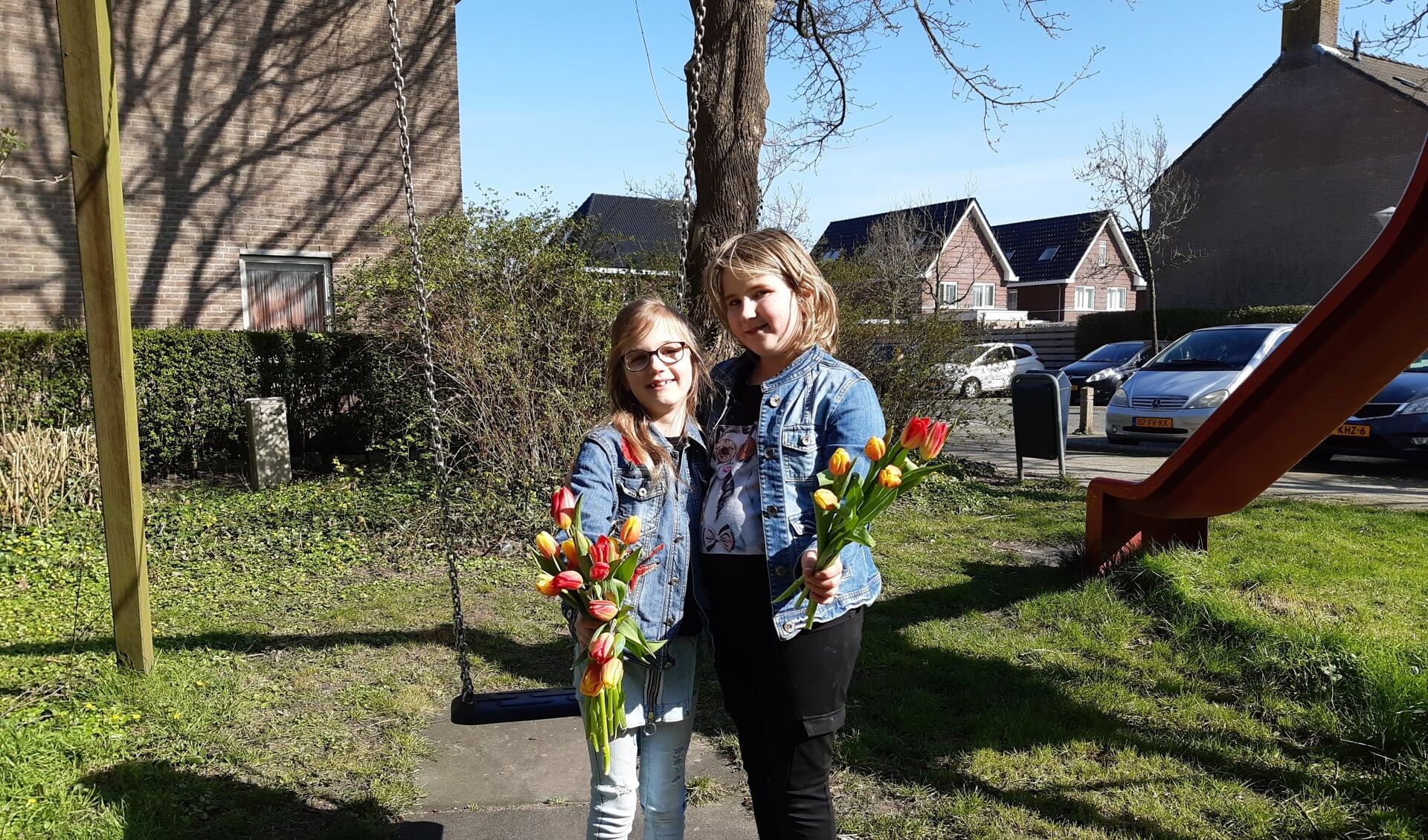 De zussen Charisa (r) en Charill hebben tulpen rondgebracht in hun eigen buurt in Zwaag.