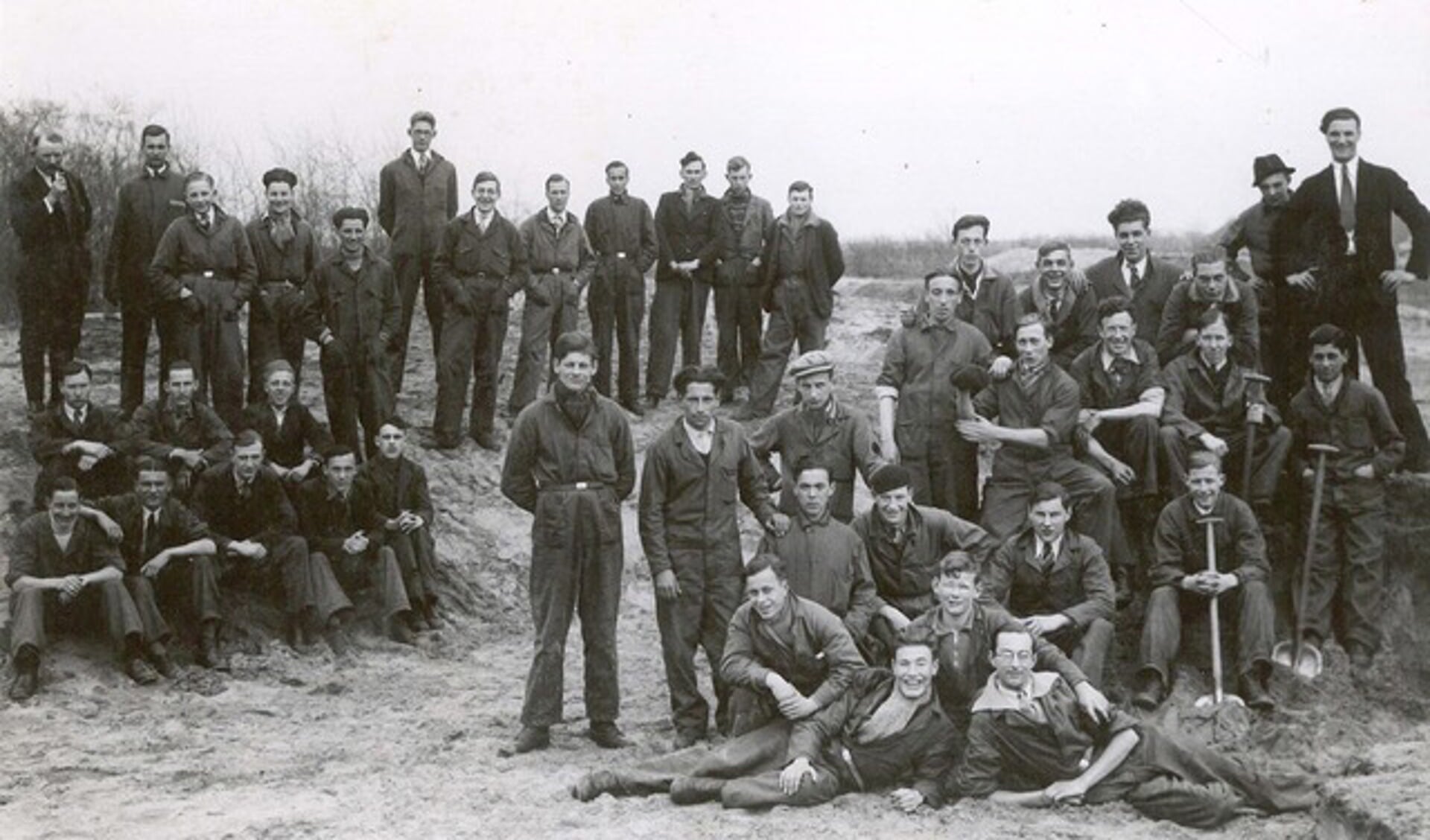 Een foto uit de jaren dertig: een groep Amsterdamse werklozen, even pauzerend tijdens terreinwerk in het duingebied. 