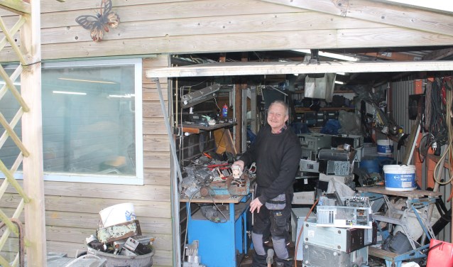 Jelle aan het werk in zijn garage waar hij alle apparaten uit elkaar haalt en oud ijzer verzamelt.