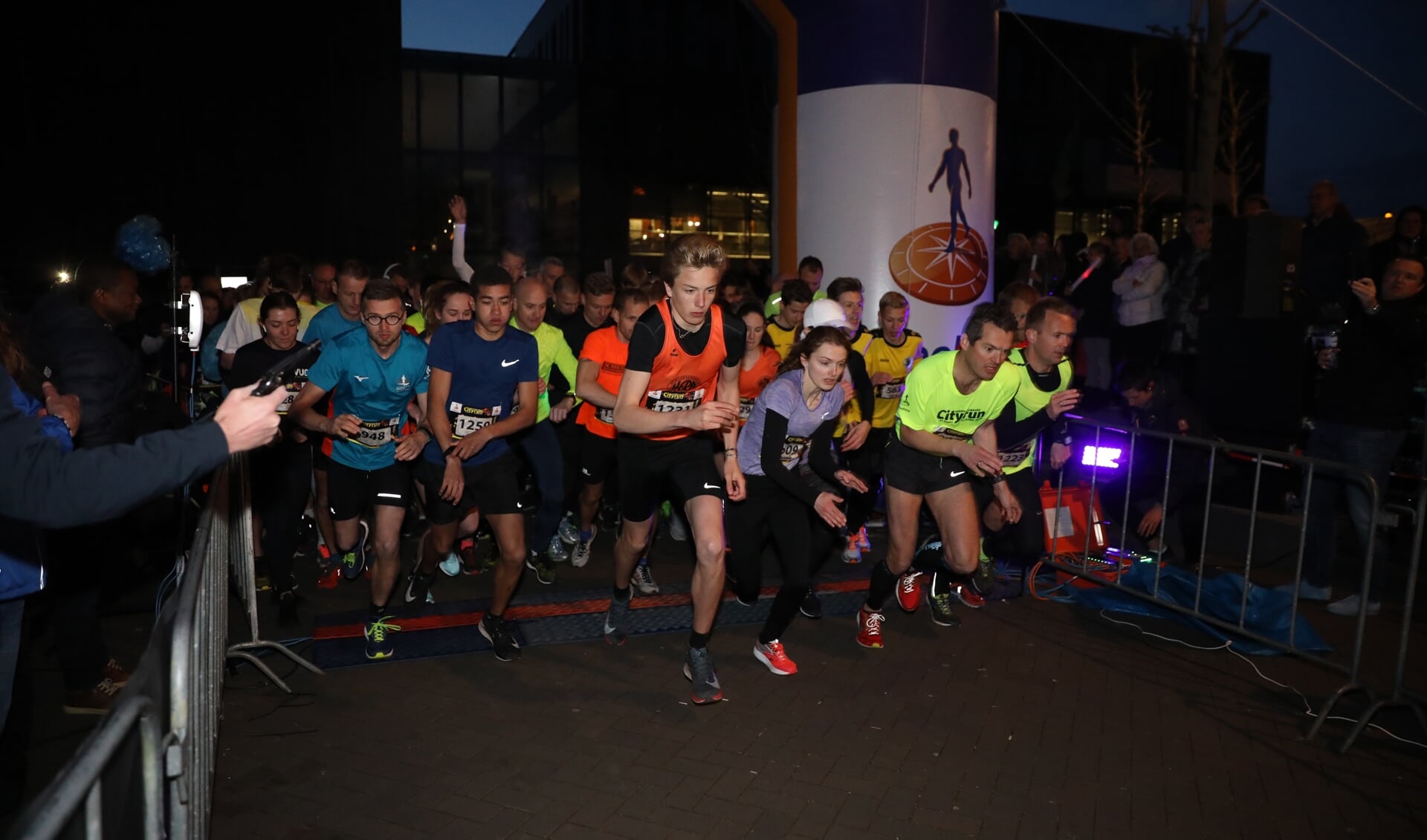 Deelnemers aan de 10,5 kilometer gaan in het donker van start.