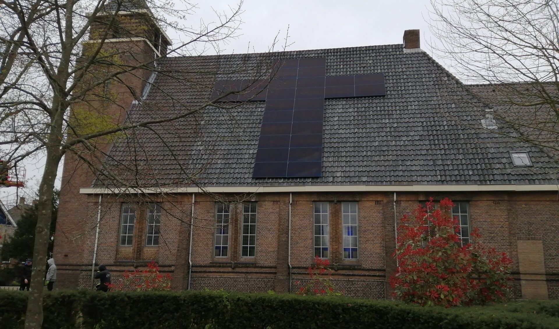 LANDSMEER - Je kunt zonnepanelen in lange rijen op je dak laten leggen, maar het kan ook anders. Op het dak van kerkgebouw Het Kruispunt zijn ze vandaag in stijl geplaatst.