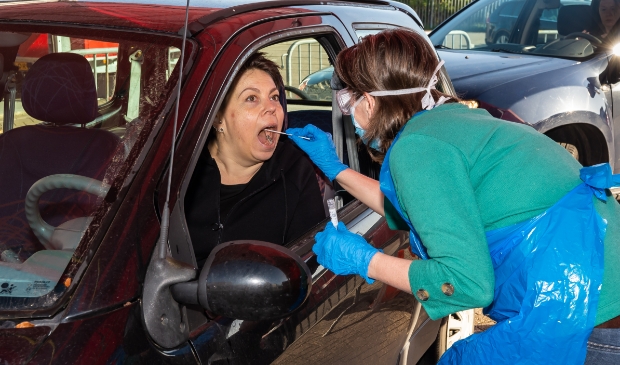 Alle zorgmedewerkers worden vanuit de auto getest door GGD-medewerkers in beschermende kleding.