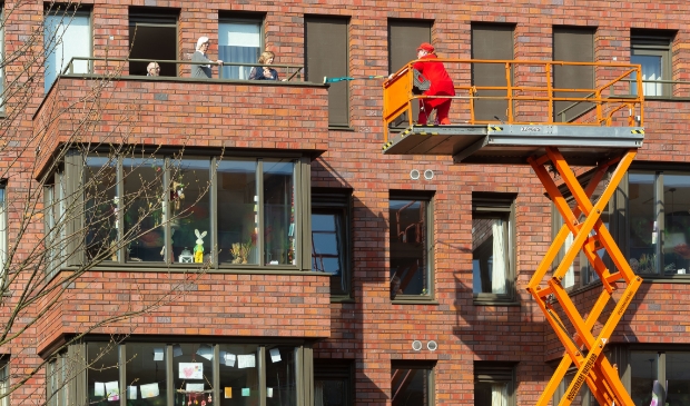 Hier wordt de clown met de hoogwerker naar een van de bewoners van Zuidland gebracht.
