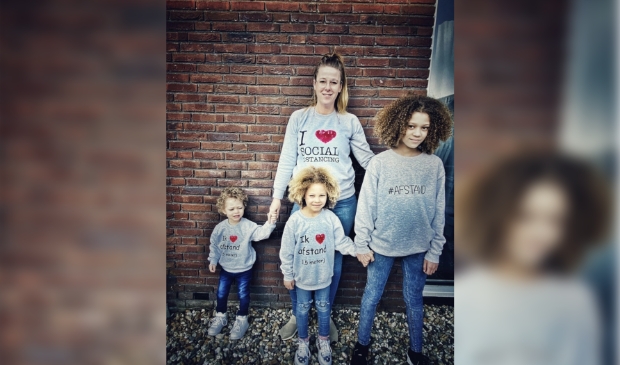 Astrid met haar kinderen dragen allemaal een zelfbedrukte trui.