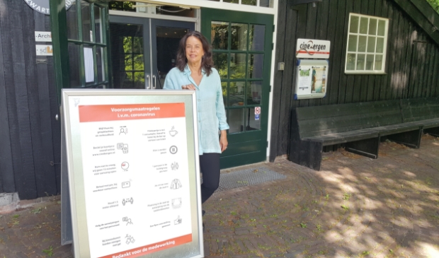 Bea Bode van Cinebergen toont het bord met alle maatregelen.