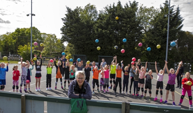 Marjon Bos met op de achtergrond de jeugdige sporters van Vrone.
