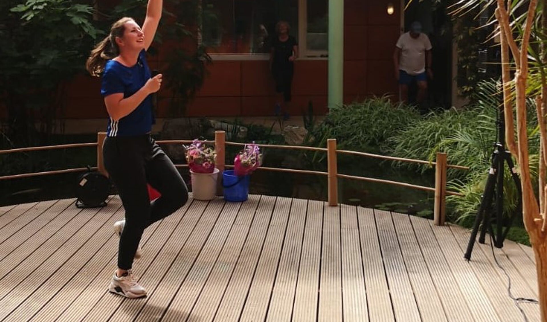 Tessa Scholte doet de oefeningen tijdens de balkongym voor aan de bewoners van het Heiligharn in Den Helder. (Foto Team Sportservice)