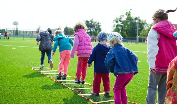 Sportende kinderen in de buitenlucht.