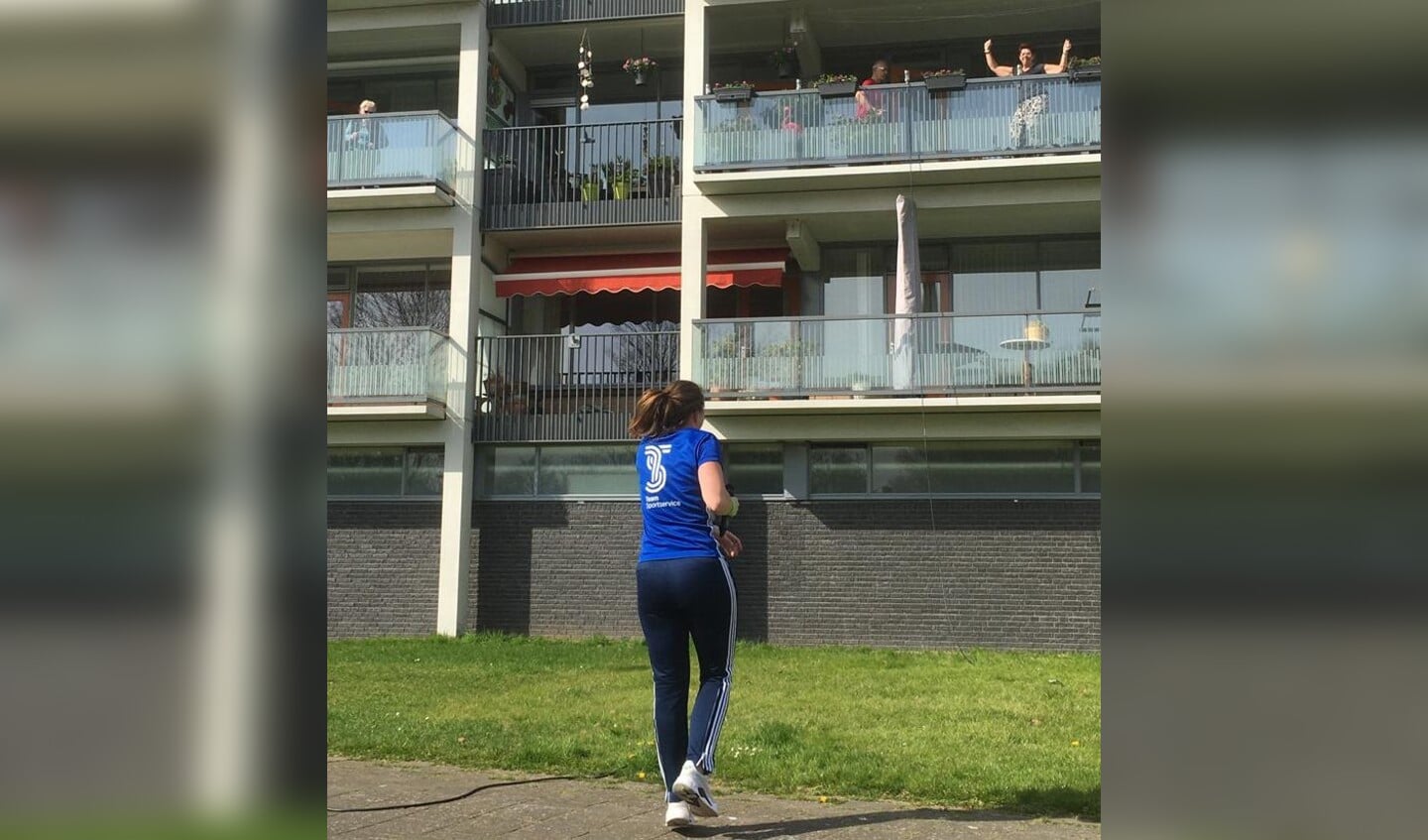 Tessa Scholte doet de oefeningen tijdens de balkongym voor aan de bewoners van het Heiligharn in Den Helder. (Foto Team Sportservice)