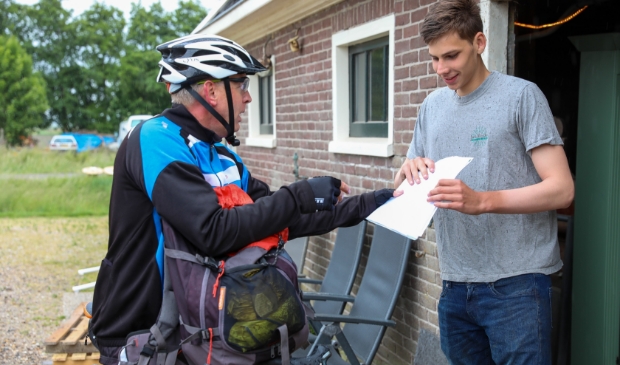 Bob ontvangt van docent Hans Visser zijn cijferlijst en een geslaagd vlag.