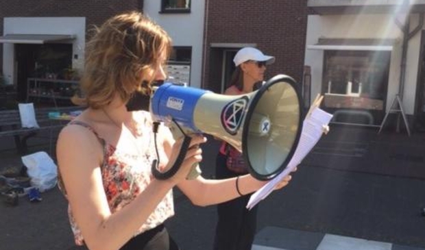 Extinction Rebellion Castricum las vrijdag 26 juni op het Bakkerspleintje verhalen voor van slachtoffers van klimaatverandering