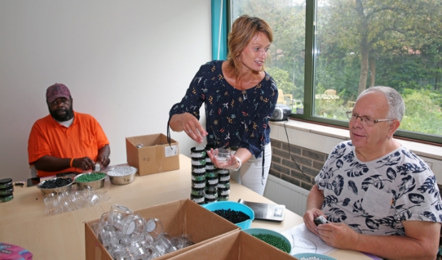Teamleider Yvette Roet helpt cliënten Orfeo (l) en Ed op weg.