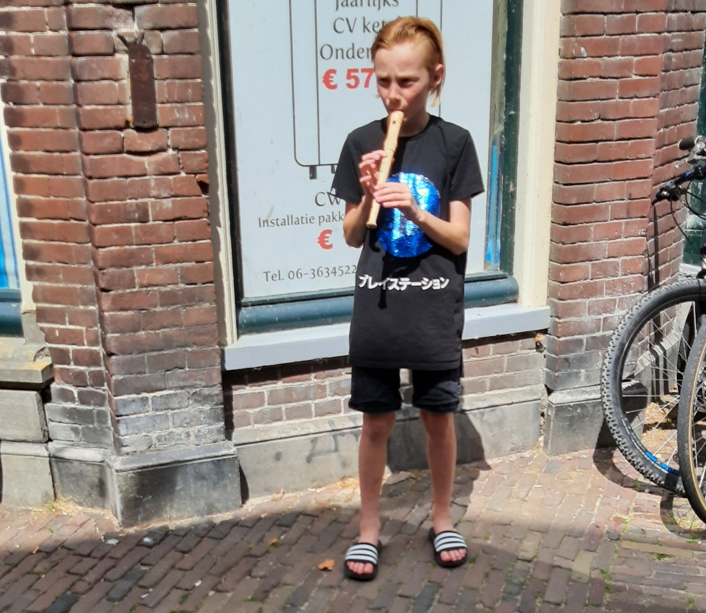 Regilio in de Westerstraat in Enkhuizen toen hij nog op zijn oude fluit speelde. Vanmiddag kreeg hij een spiksplinternieuwe blokfluit.