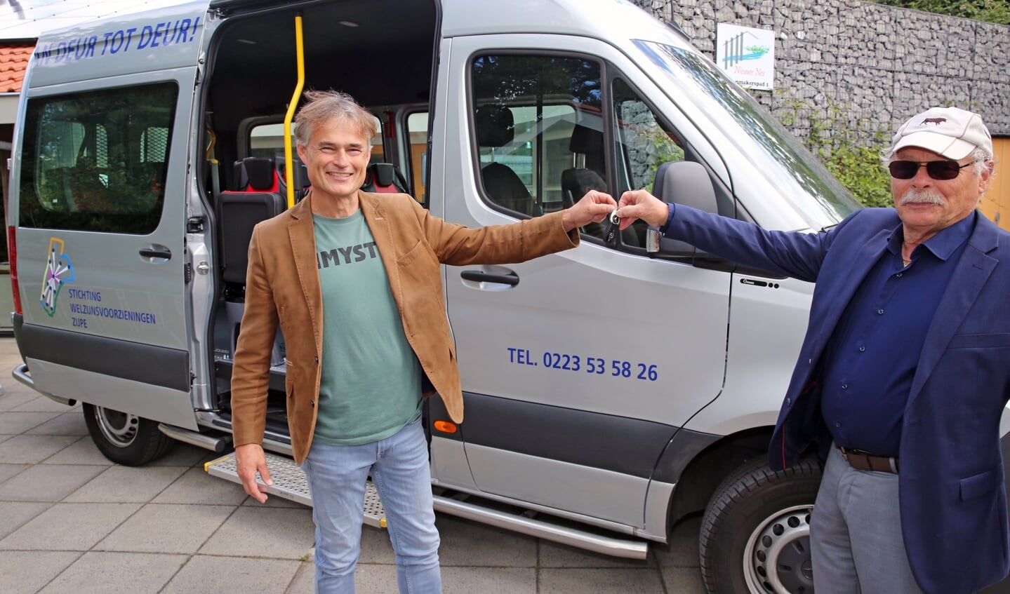 Wethouder Van der Veek geeft de sleutels van de bus aan voorzitter Gerard Apeldoorn.
