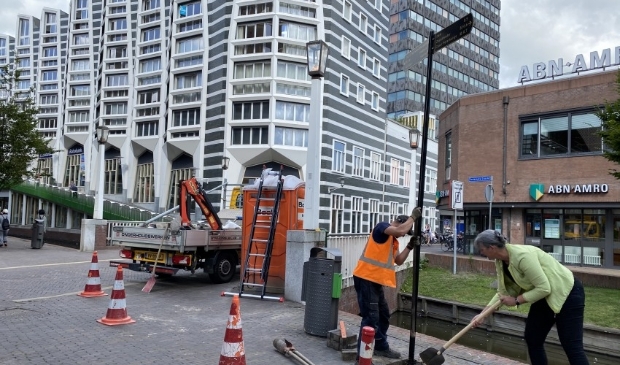 Wethouder Annette Baerveldt helpt een handje mee bij het plaatsen van de nieuwe bewegwijzering.