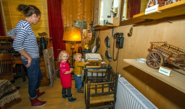 Kinderen kijken hun ogen uit in een woonkamer anno 1950.