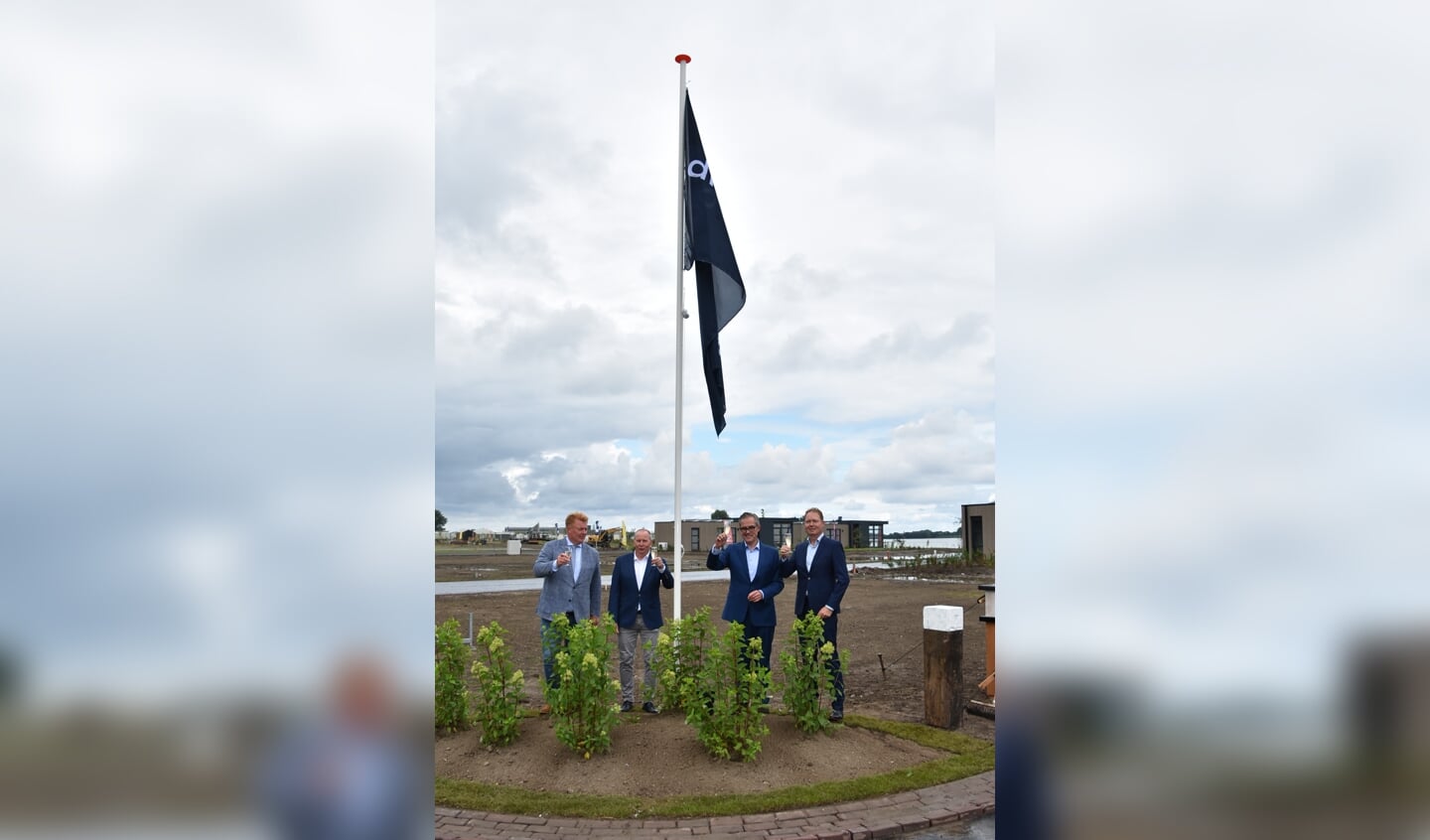 Wethouder Erik Struijlaart en Andries Bruil van Droomparken links en rechts van de zojuist gehesen vlag.