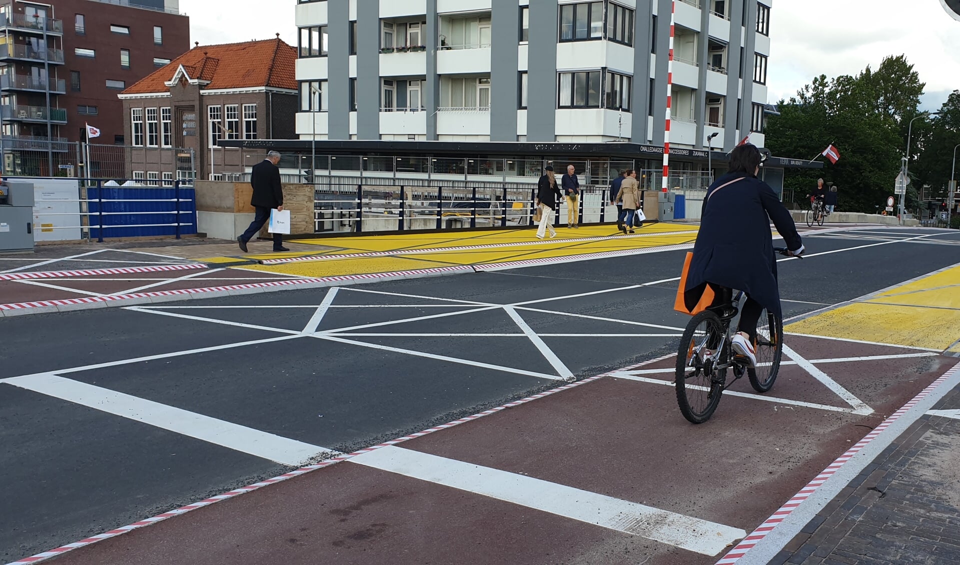 Een wirwar van lijnen, gele vlakken en gemarkeerde randen op de Beatrixbrug. En voor wie dit allemaal ontgaat staan er ook nog verkeersregelaars die ervoor moeten zorgen dat de fietsers niet onderuit gaan. 